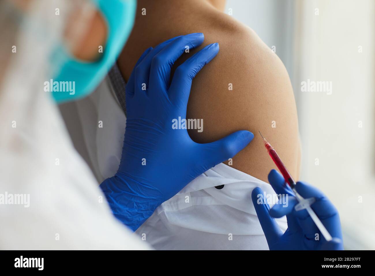 Primo piano di somministrazione di vaccino da parte dell'infermiere al paziente maschio durante il trattamento in clinica, copiare lo spazio Foto Stock