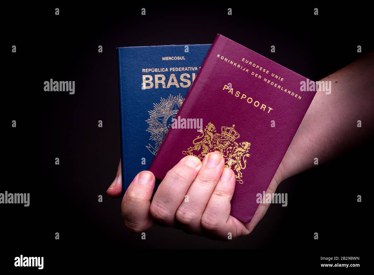 Con due passaporti, passaporto brasiliano ed europeo -Olandese-. Concetto di doppia nazionalità. Foto Stock