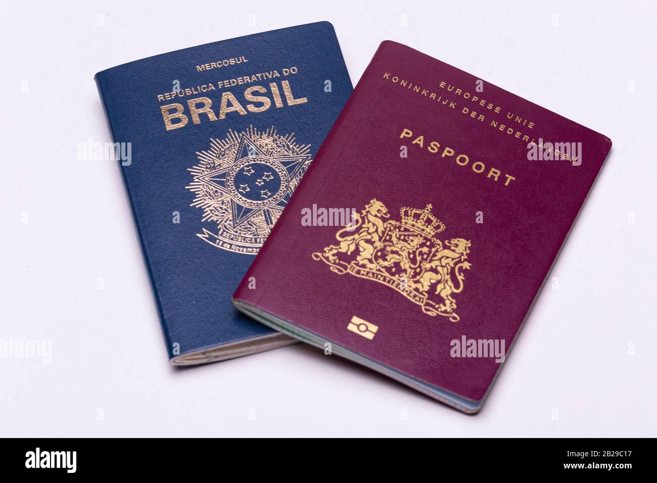 Europeo - Olandese - in cima a un passaporto internazionale brasiliano un brillante sfondo di superficie. Concetto di doppia nazionalità. Foto Stock
