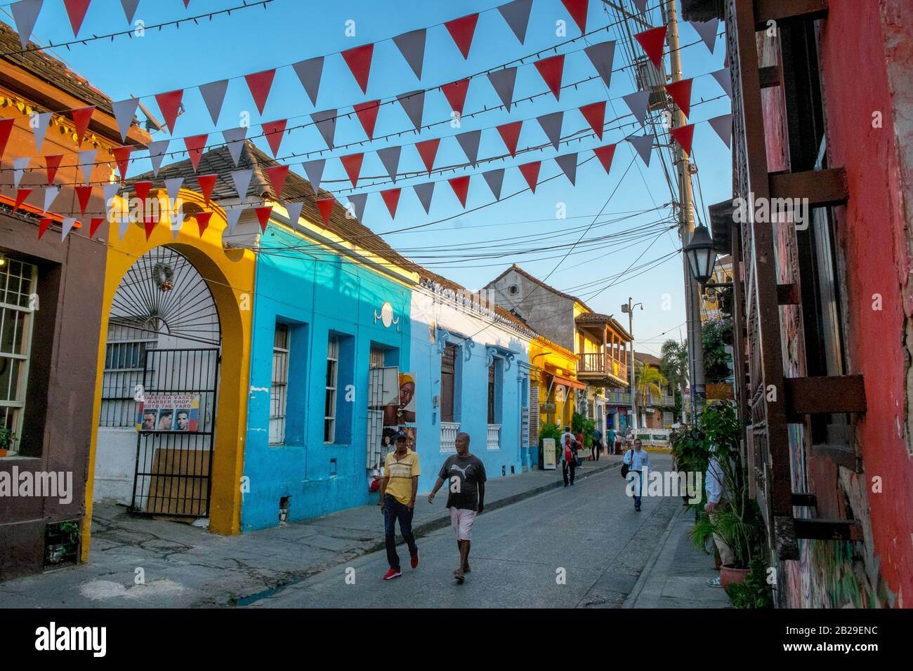 Persone che camminano attraverso case colorate nel quartiere Barrio Getsemaní, Cartagena, Colombia Foto Stock