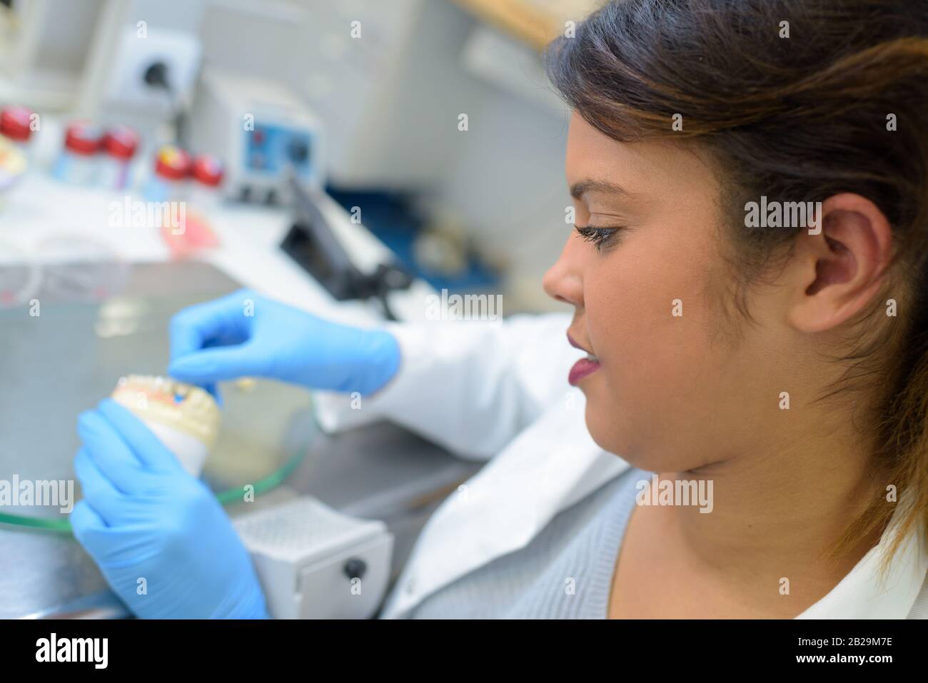 donna fare la dentiera con lo strumento Foto Stock