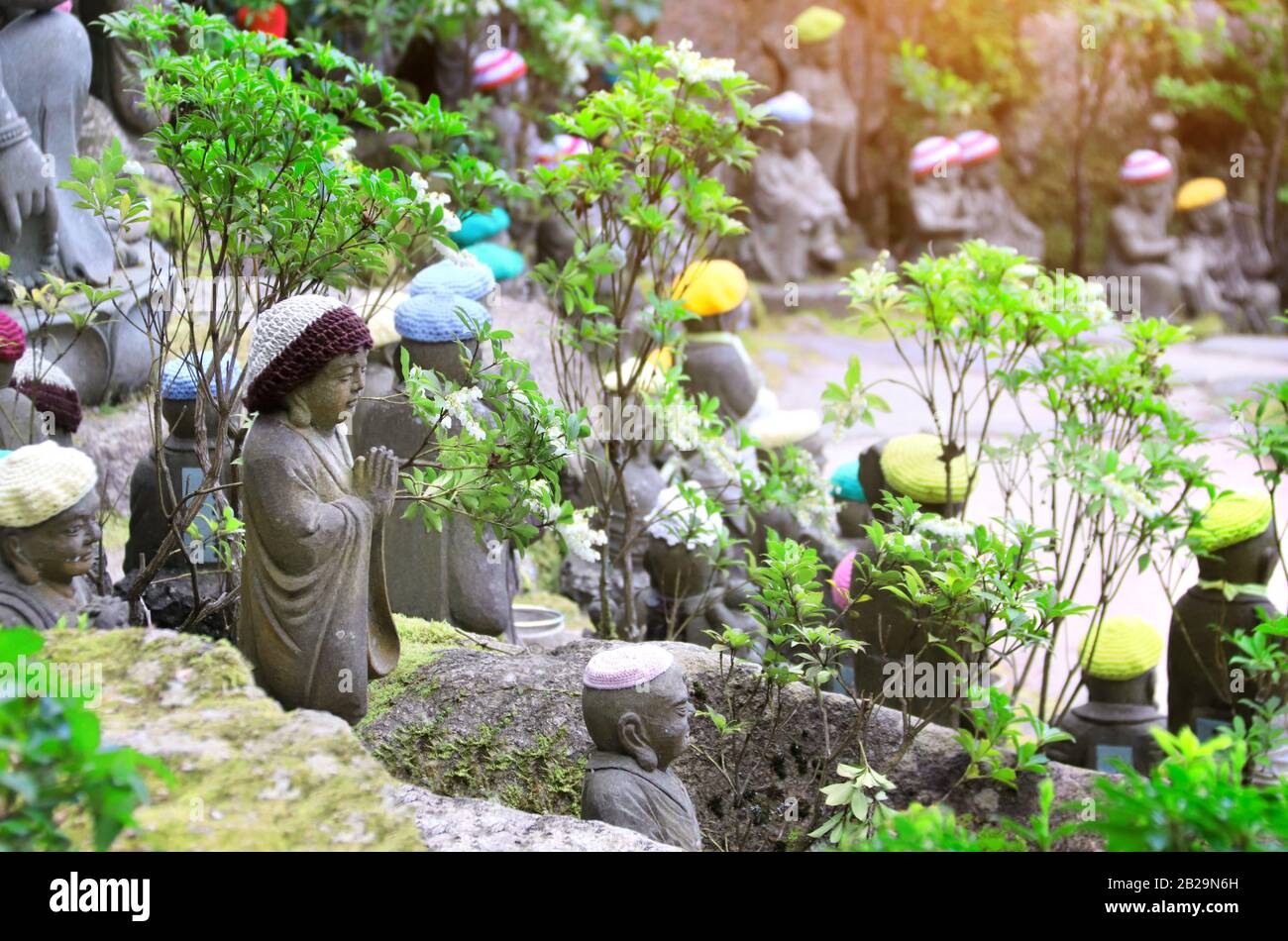 Stone Ksitigarbha statue (Jizo Bosatsu) in una maglia cappelli, Daishouin (Daishou-in) tempio buddista, sacra Miyajima island, Prefettura di Hiroshima, regi Foto Stock