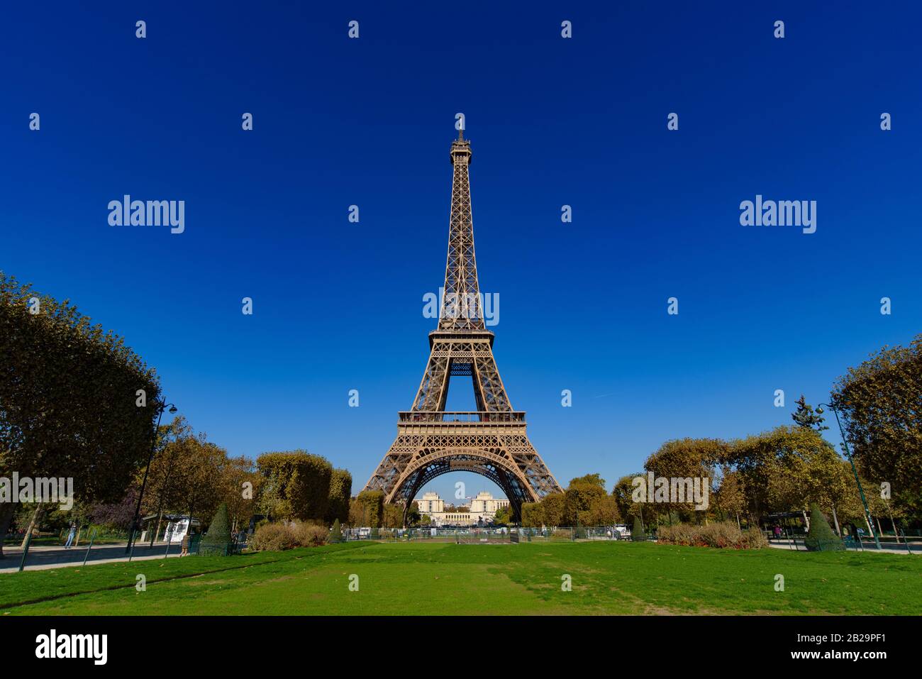 Torre Eiffel con Champs de Mars e cielo blu soleggiato a Parigi, Francia Foto Stock