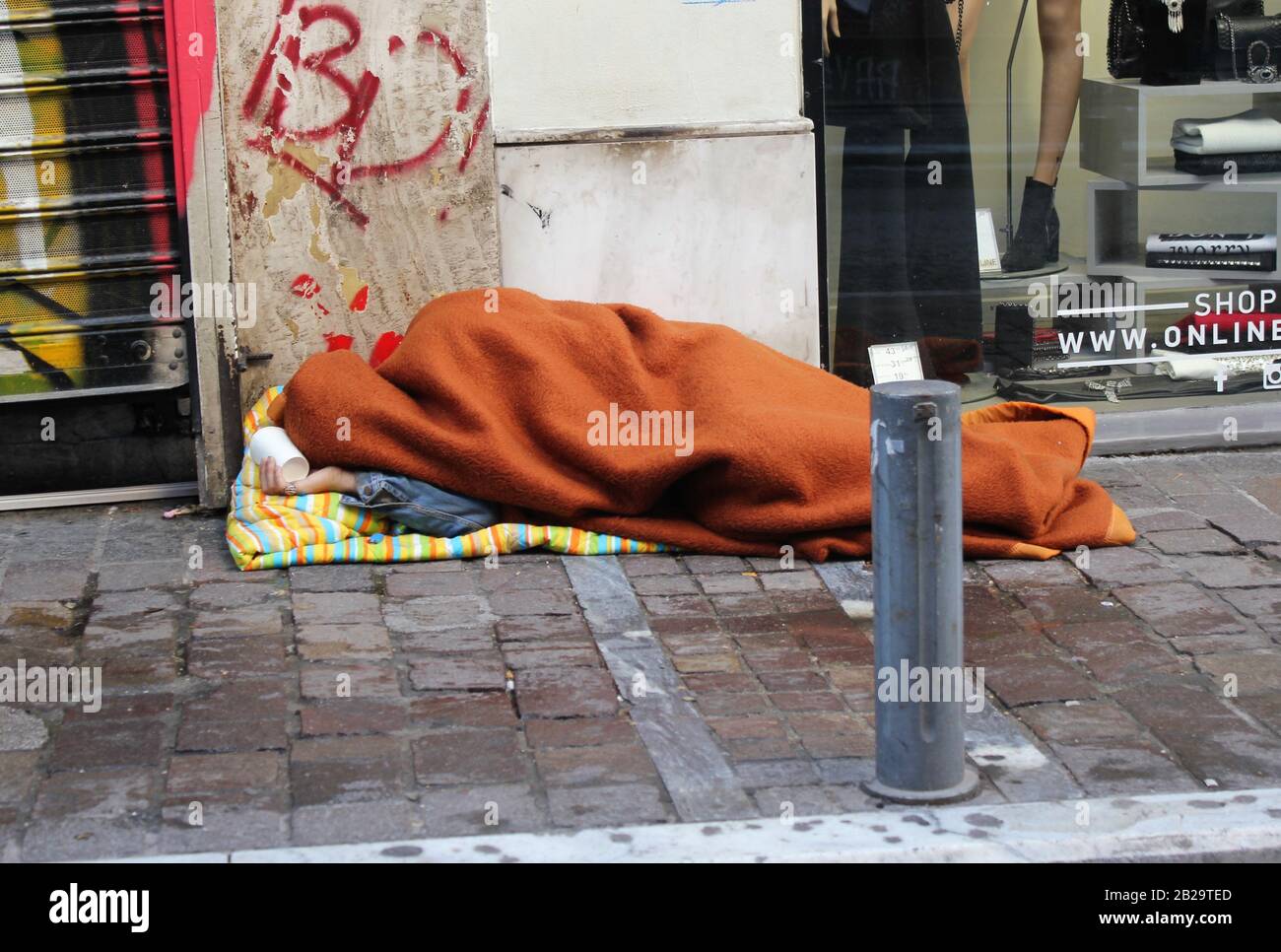 Senzatetto che dorme su un marciapiede stradale, Atene, Grecia, 22 novembre 2019 Foto Stock