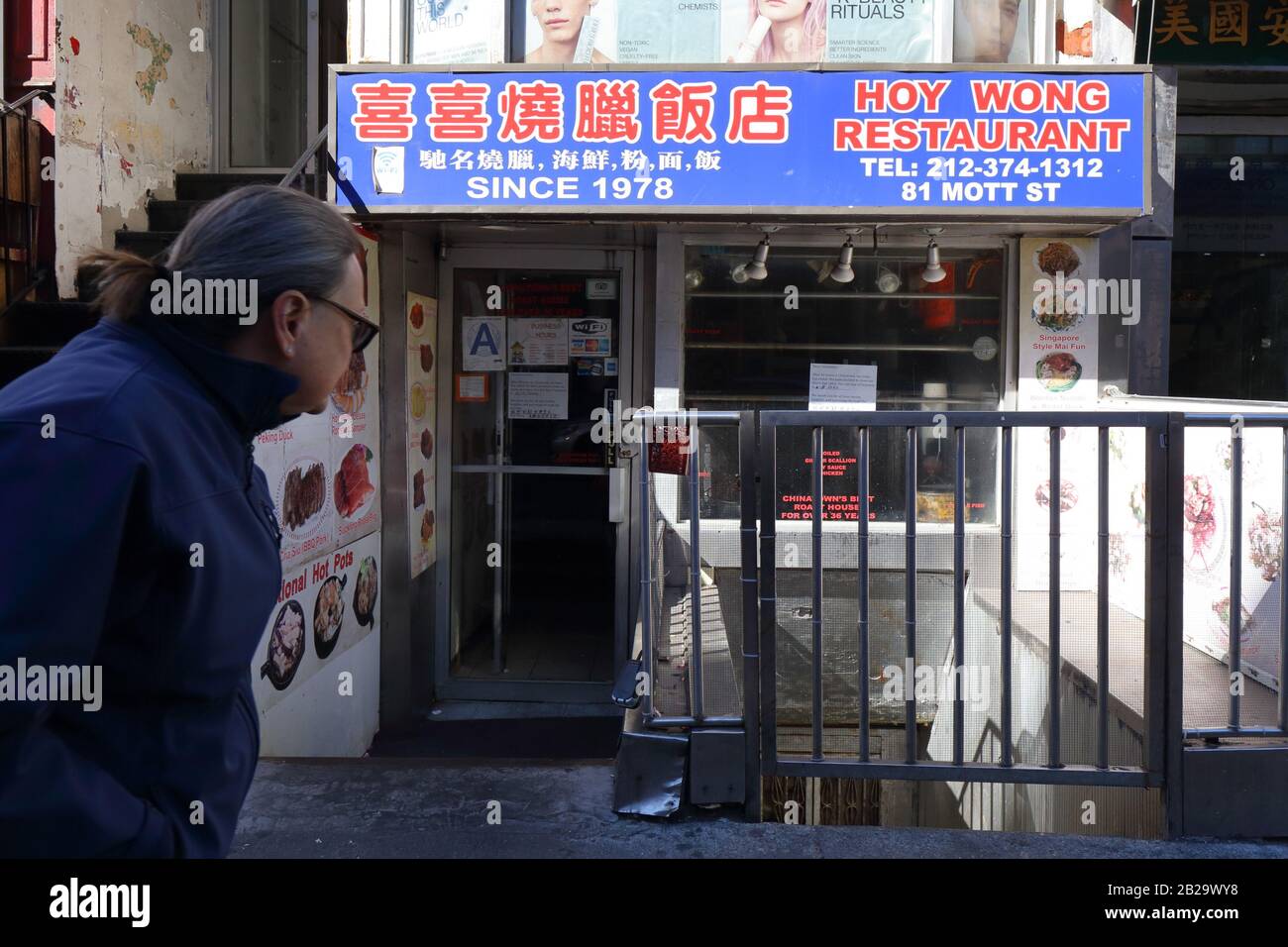 Una persona cammina presso il ristorante Hoy Wong con un cartello nella finestra che indica che l'azienda è chiusa dopo 42 anni di attività, New York NY. Foto Stock