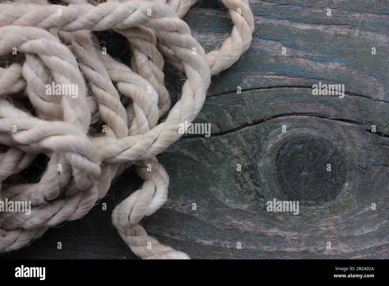 Vecchio sfondo testurizzato. Nave corda su un tavolo di legno ruvido. Colori scuri. Vista dall'alto. Spazio di copia Foto Stock