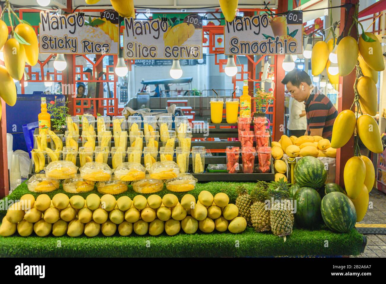 Mango a fette, pinapple e melone in vendita presso una stalla alimentare di strada, Bangkok, Thailandia Foto Stock