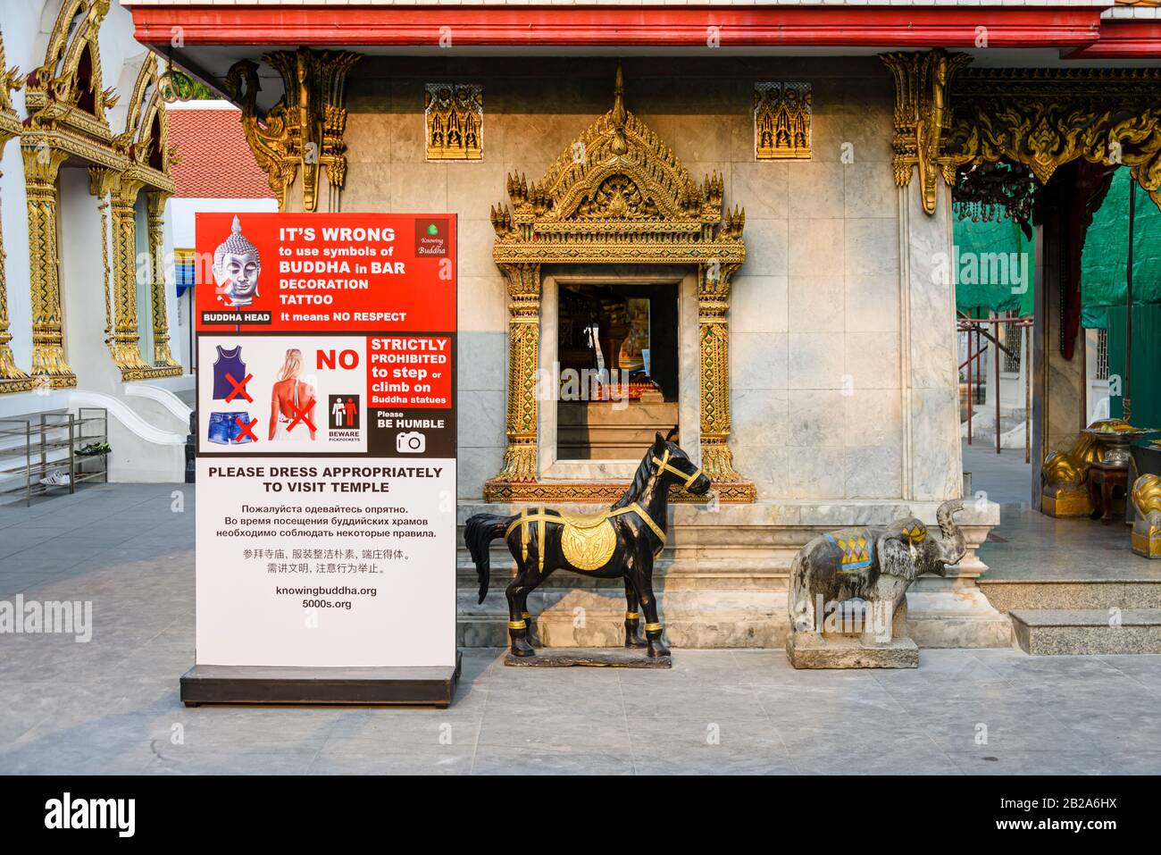 Firma fuori di un tempio buddista che consiglia ai visitatori di vestirsi e agire in modo appropriato a Wat Chana Songkhram, Bangkok, Thailandia Foto Stock