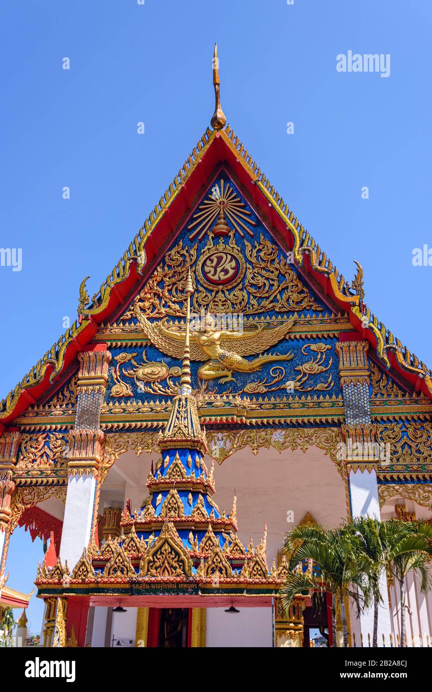 Decorazioni ornate sul tetto e statue dorate al tempio buddista Wat Mongkhon Nimit, nella città vecchia di Phuket, Thailandia Foto Stock