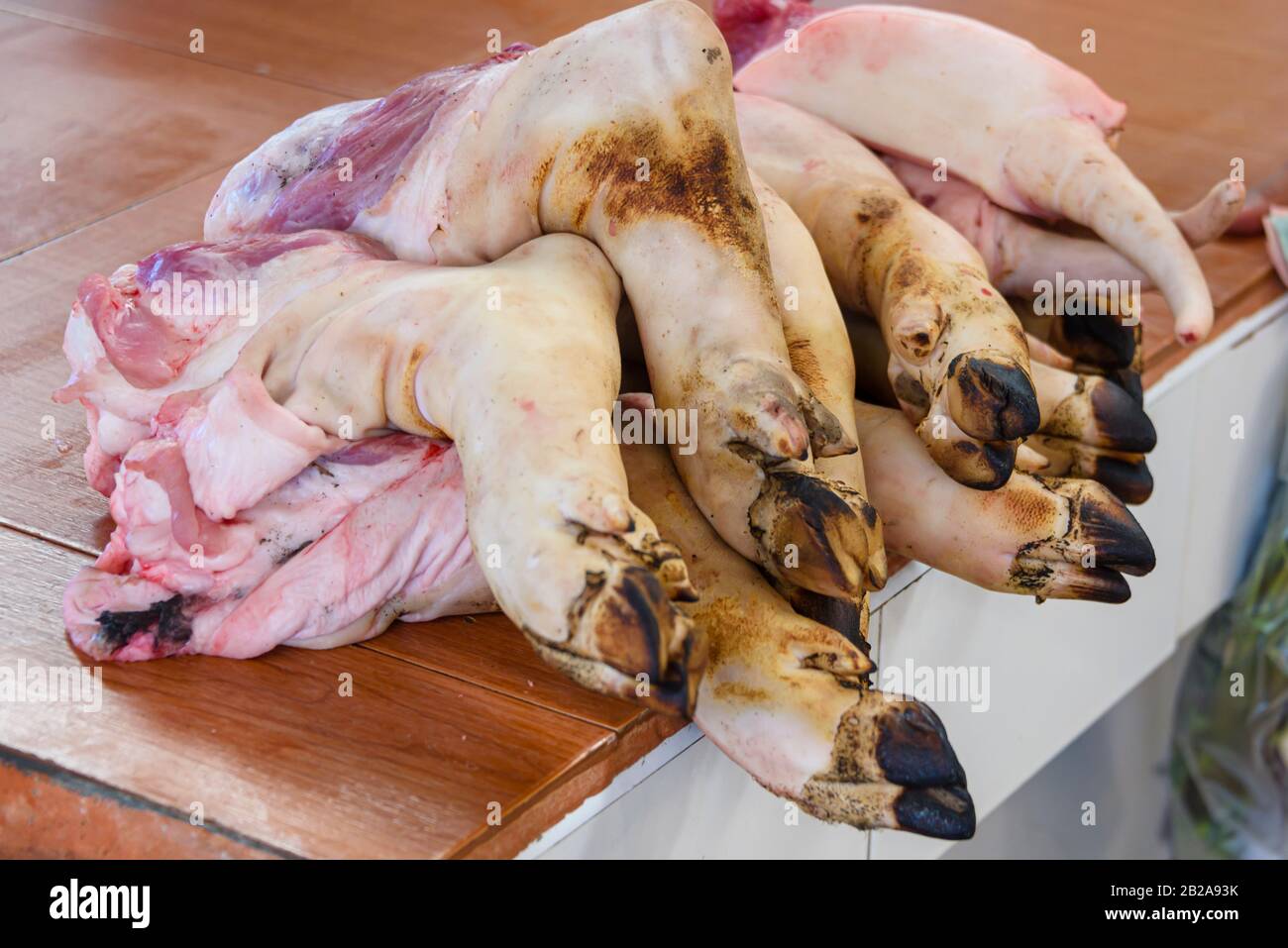 Pig piedi trotters in vendita presso lo stallo macellaio nel tradizionale Mae Somchit Kata Fresh Market, Kata, Phuket, Thailandia Foto Stock