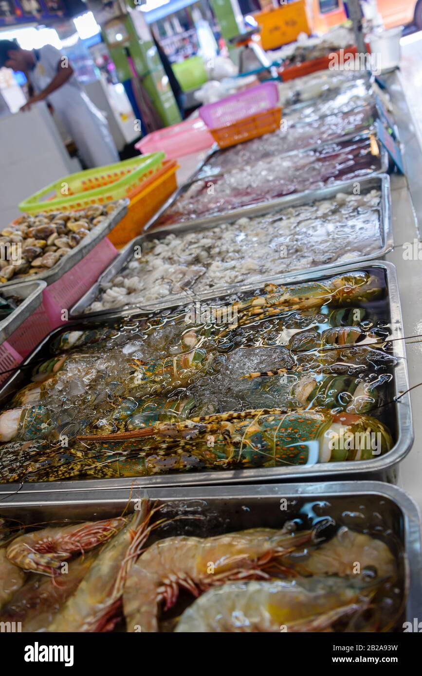 Gamberi, vongole, calamari e altri molluschi in vendita presso una stalla di pescatori nel tradizionale mercato Fresco di Mae Somchit Kata, Kata, Phuket, Thailandia Foto Stock