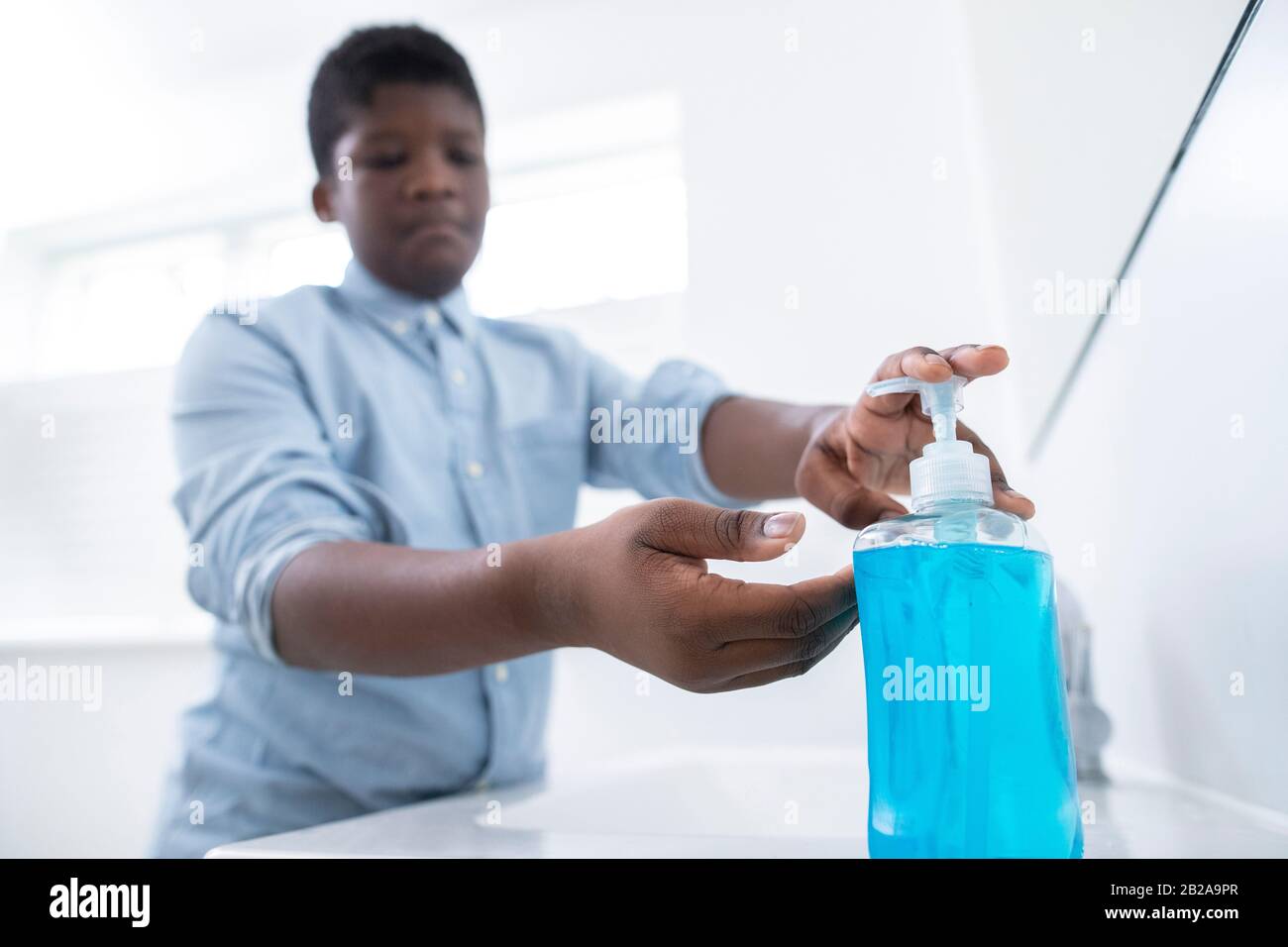 Ragazzo Lavarsi Le Mani Con Sapone A Casa Per Prevenire L'Infezione Foto Stock