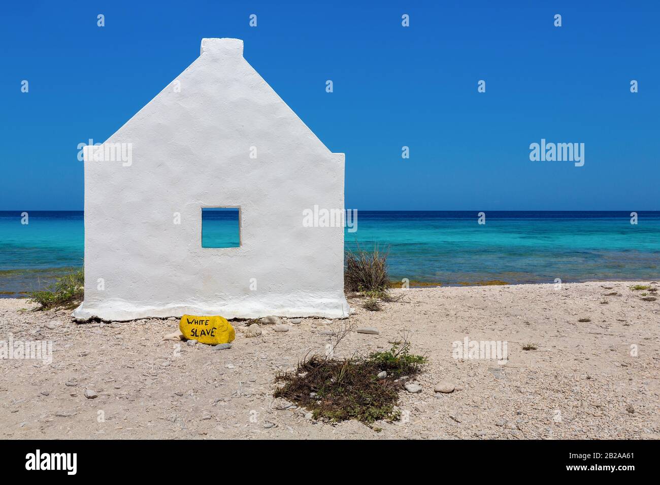 Una casa bianca slave sulla costa con mare blu sull'isola Bonaire Foto Stock
