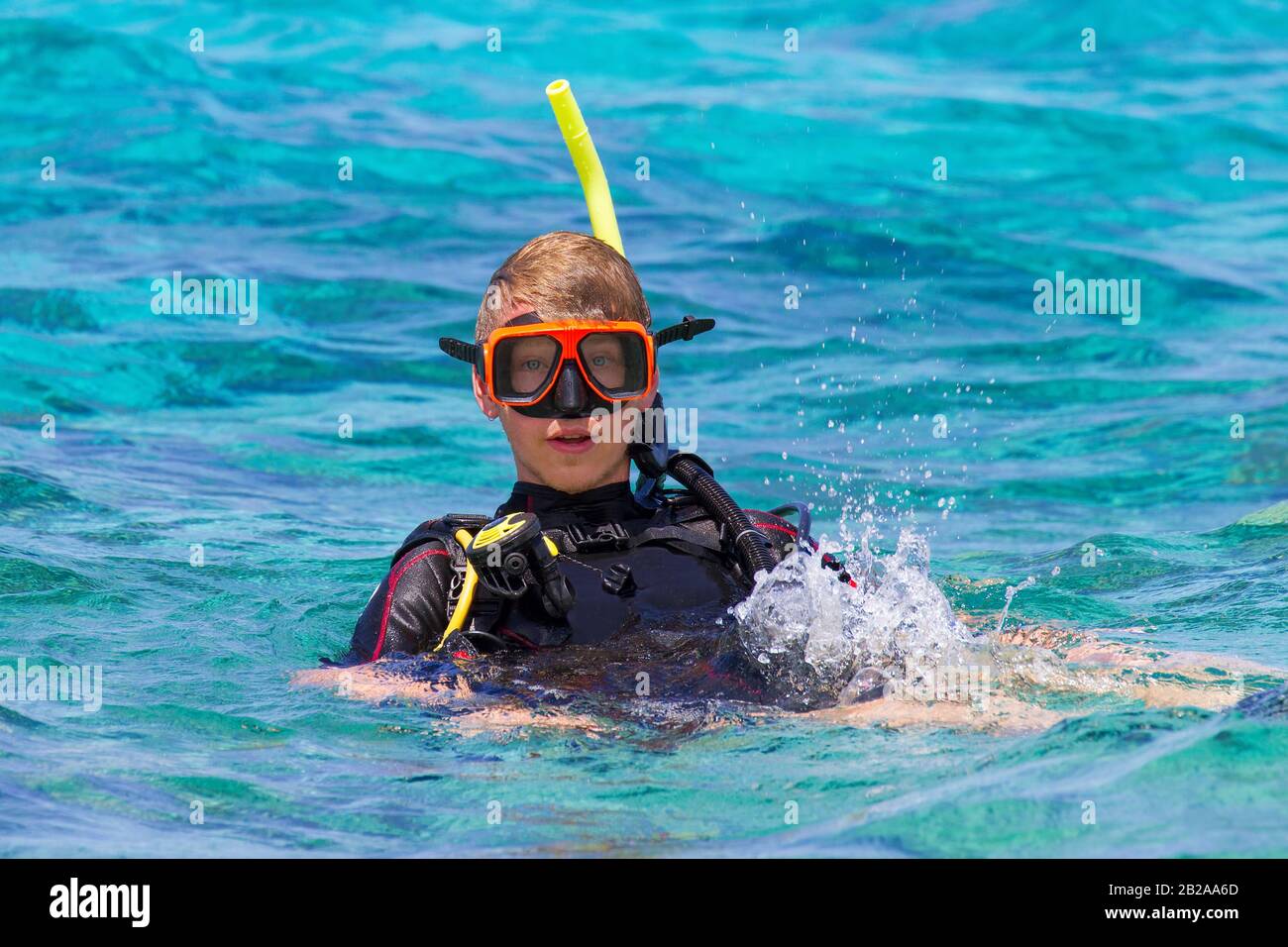 Giovane subacqueo caucasico maschio galleggia in acqua di blu oceano Foto Stock