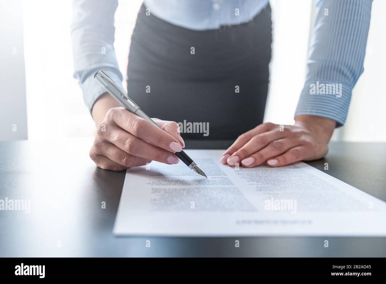 Donna d'affari che firma il documento di contratto sulla scrivania dell'ufficio, facendo un affare. Foto Stock