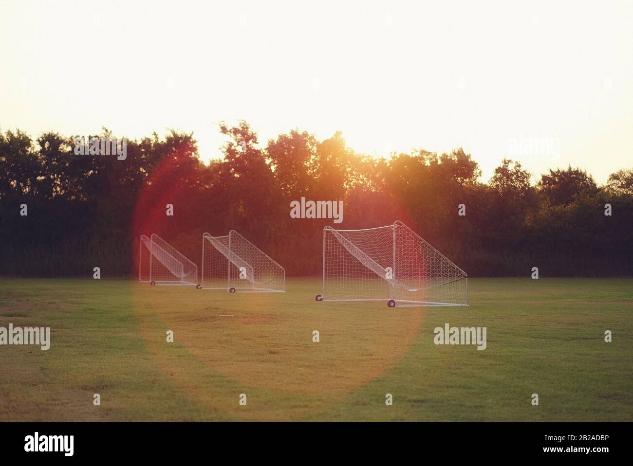 Tre obiettivi di calcio in fila in un campo di calcio all'alba, Stati Uniti Foto Stock