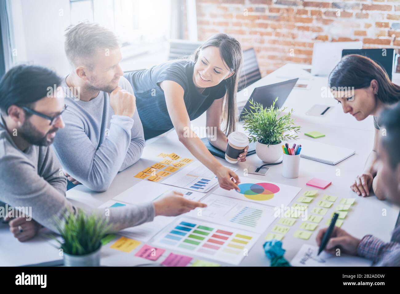 La gente di affari riunione in ufficio e uso di post-it per condividere idea. Concetto di brainstorming. Nota adesiva sulla parete di vetro. Foto Stock