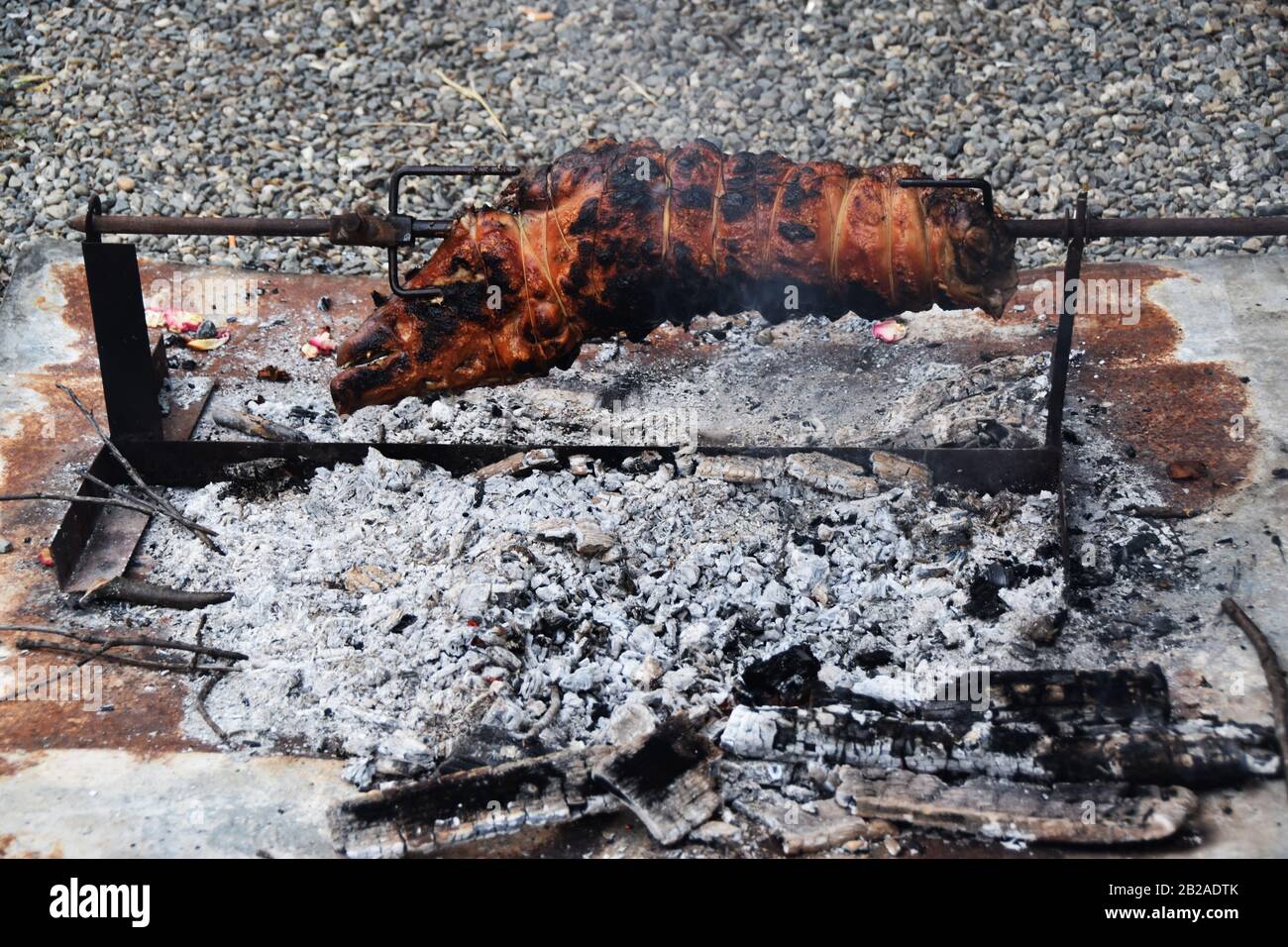 Spiedo arrosto di maiale arrostito sopra un fuoco Foto Stock