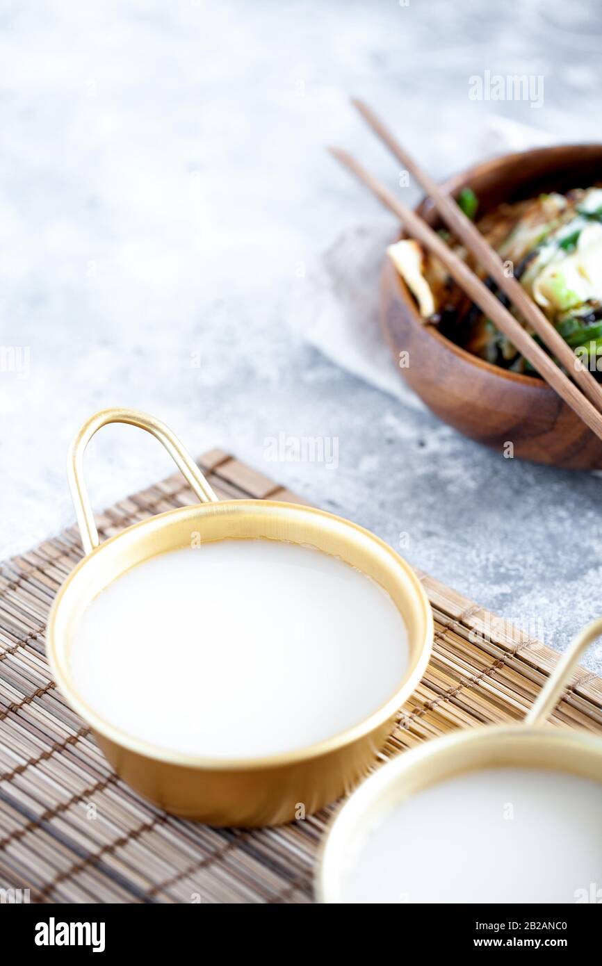 Il riso Makgeolli è uno dei più antichi vini coreani tradizionali fermentati. Bevanda sana asiatica. Orientamento verticale Foto Stock