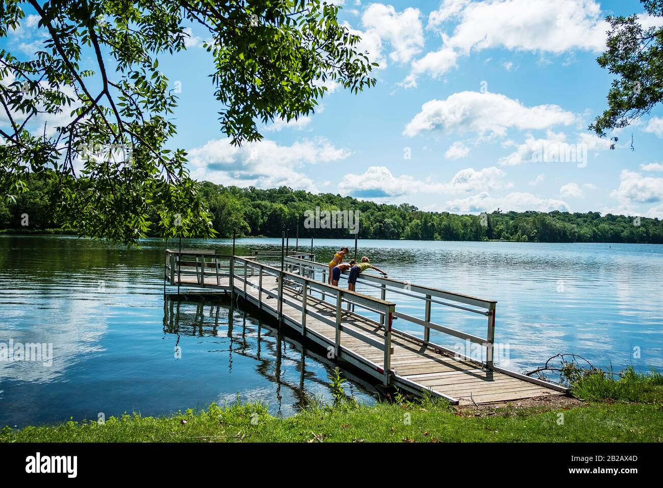 Tre bambini che pescano su un molo, USA Foto Stock