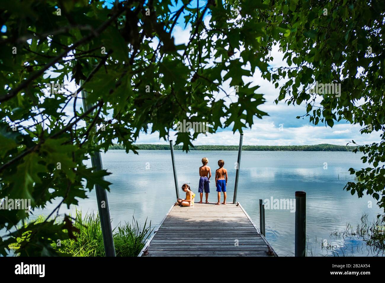 Tre bambini su un molo di pesca, Stati Uniti Foto Stock
