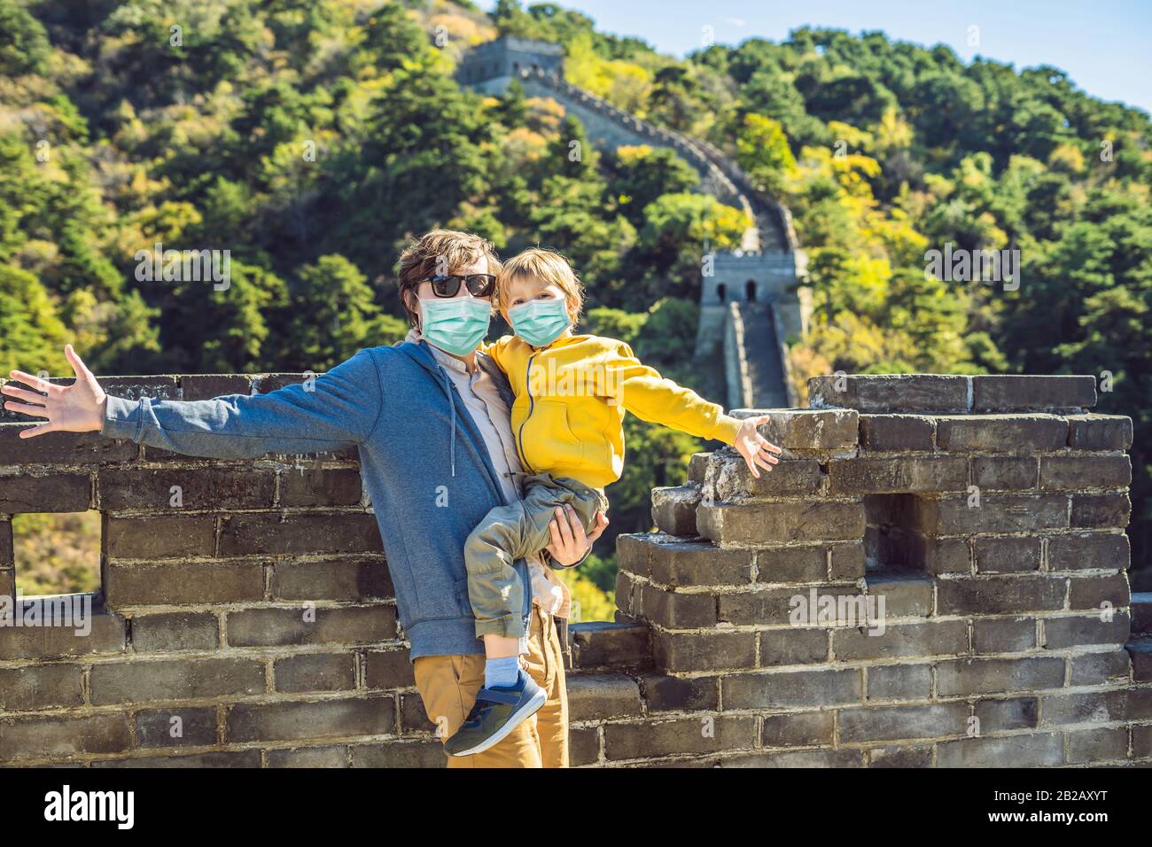 Turisti papà e figlio in maschere mediche alla Grande Muraglia della Cina. Destinazione cinese. Viaggi con i bambini in Cina concetto. I turisti temono il 2019-ncov Foto Stock