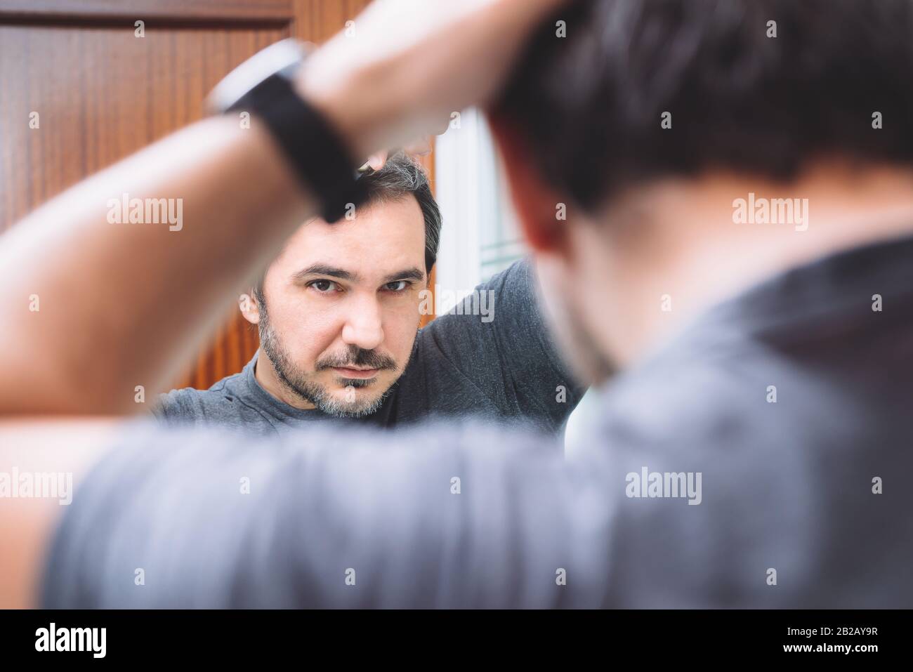 40s uomo pettina i capelli in bagno Foto Stock