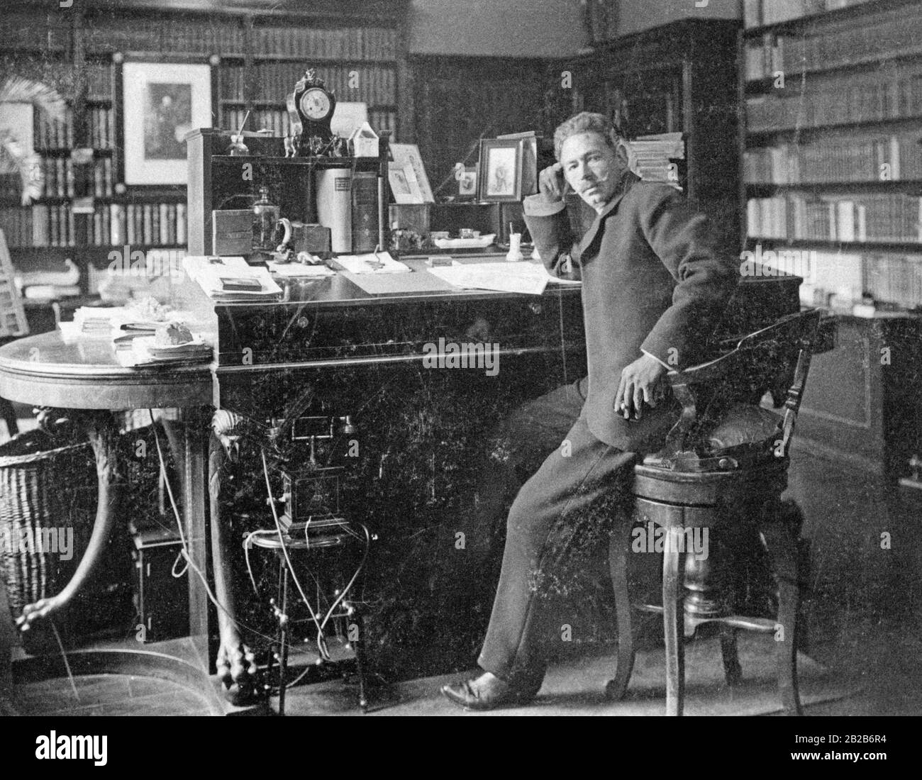 L'editore Albert Brockhaus nel suo ufficio a Lipsia, arredato nello stile del tempo con una sedia alta e una scrivania alta. Foto Stock