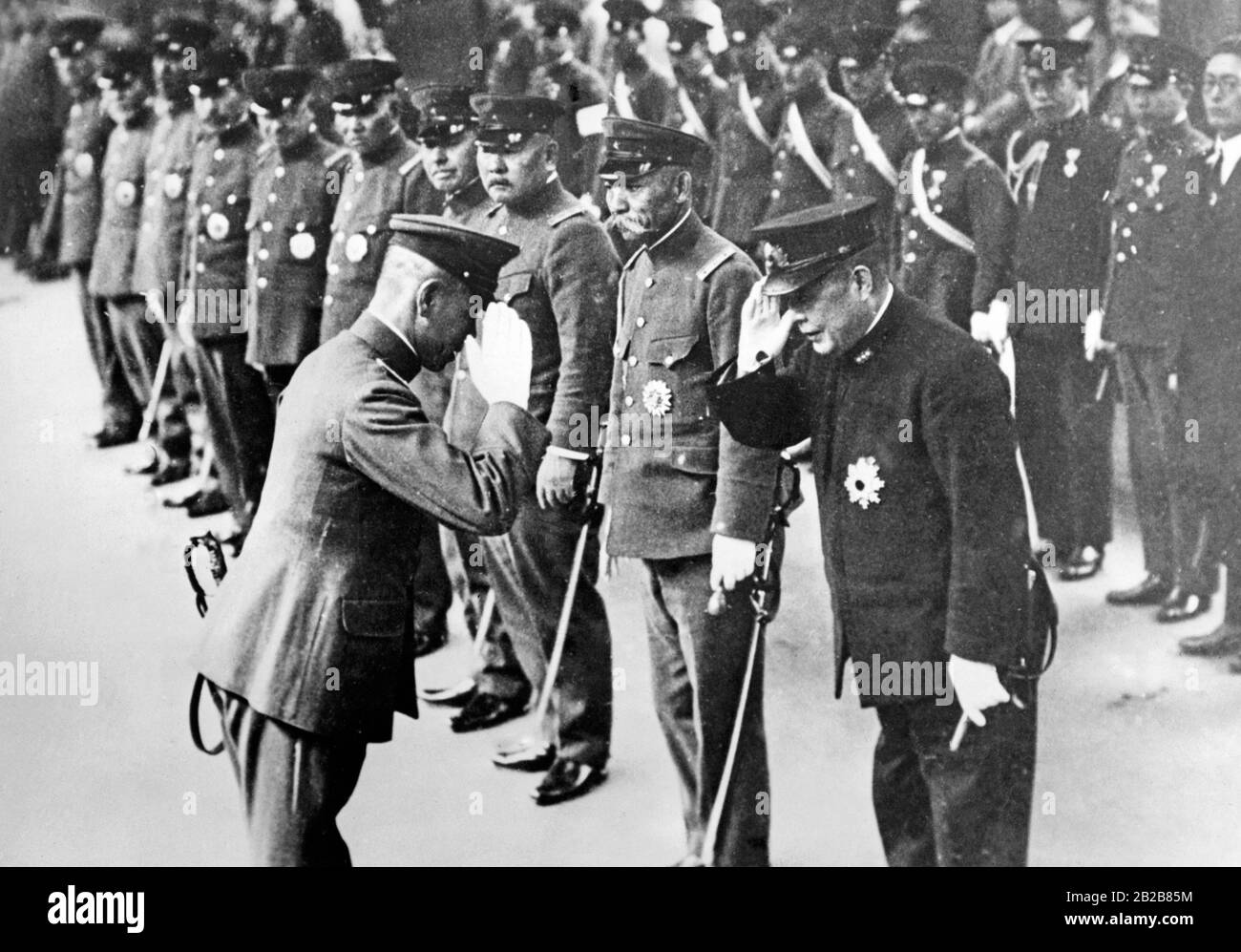 Il tenente generale giapponese Kataro Nakamura (a sinistra) viene salutato con un saluto dal Ministro giapponese della Marina Ammiraglio Osumi a Tokyo. Accanto a loro, il ministro giapponese della guerra, il generale Hayashi. Foto Stock