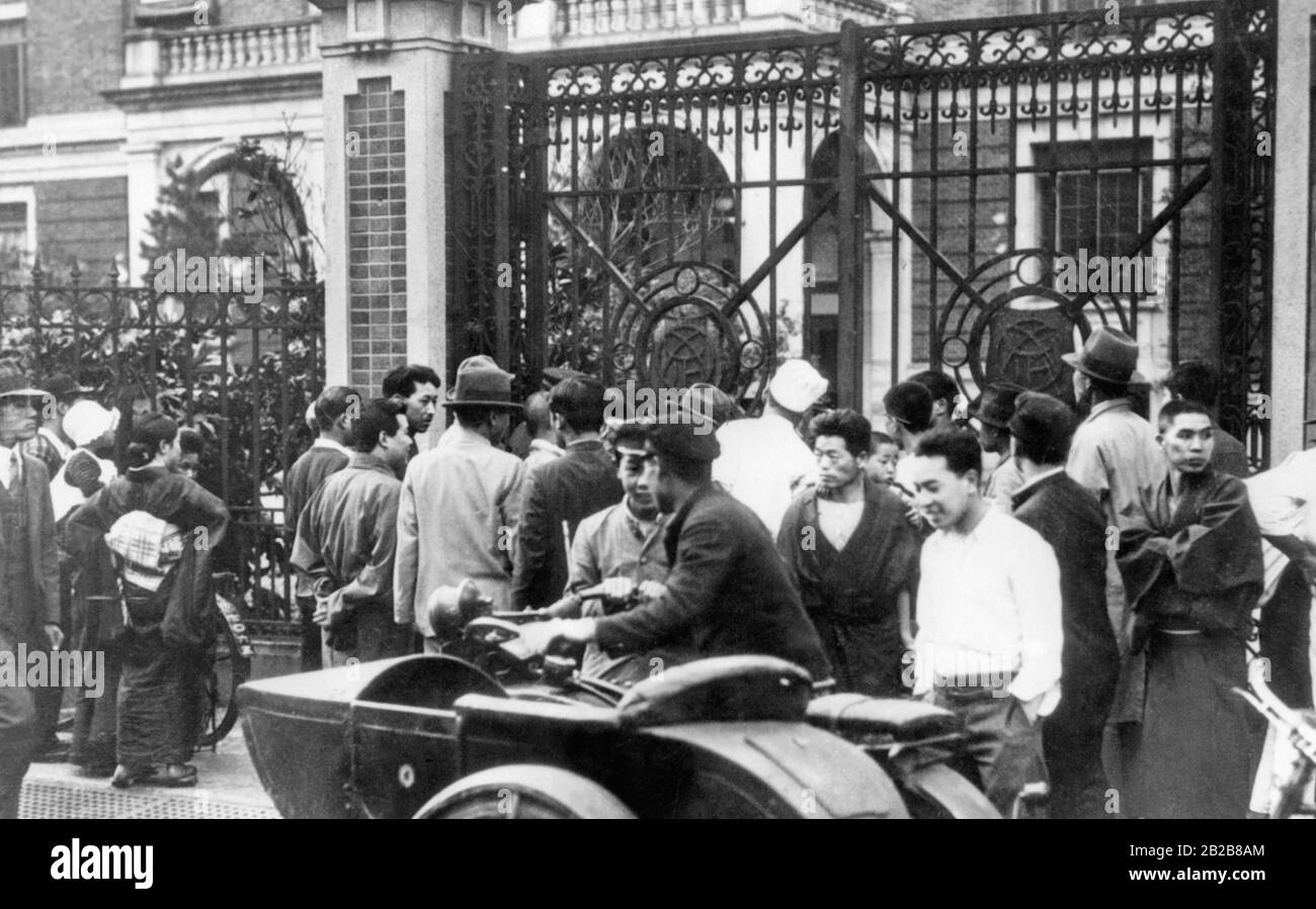 Vista delle porte della sede del partito giapponese Rikken Seiyukai a Tokyo il 15 maggio 1932 dopo un attacco di ufficiali navali. L'attacco faceva parte di un tentativo di colpo di stato su larga scala, fallito, in cui l'allora primo ministro del Giappone, Inukia Tsuyoshi, fu ucciso. Una folla di persone si è formata al di fuori delle porte. Foto Stock