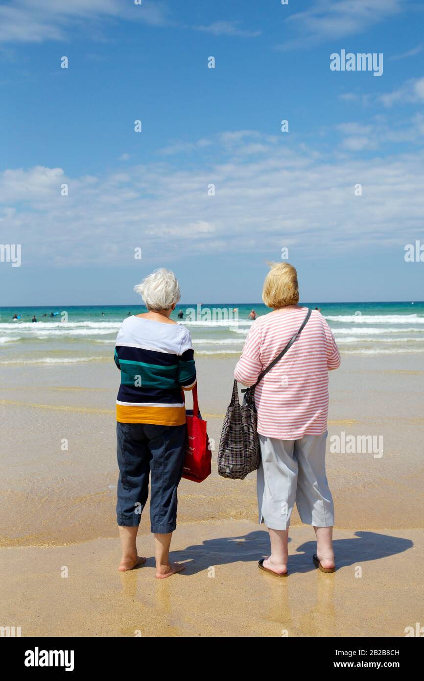 Signore sulla spiaggia, Watergate Bay, Cornovaglia Foto Stock