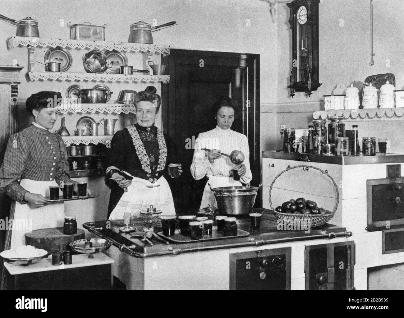 Il cuoco e i suoi aiutanti che conservano la frutta in una famiglia di classe media alla fine del secolo. La foto è ondulata. Foto Stock