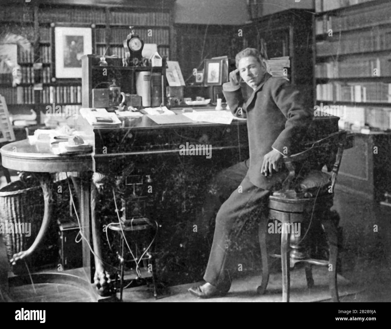 L'editore Albert Brockhaus nel suo ufficio a Lipsia, arredato nello stile del tempo con una sedia alta e una scrivania alta. Foto Stock