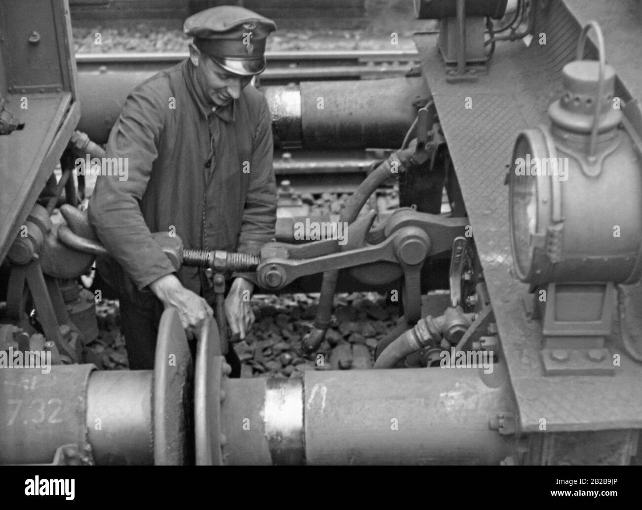 Dipendente ferroviario che lavora tra due vagoni ferroviari. Foto Stock