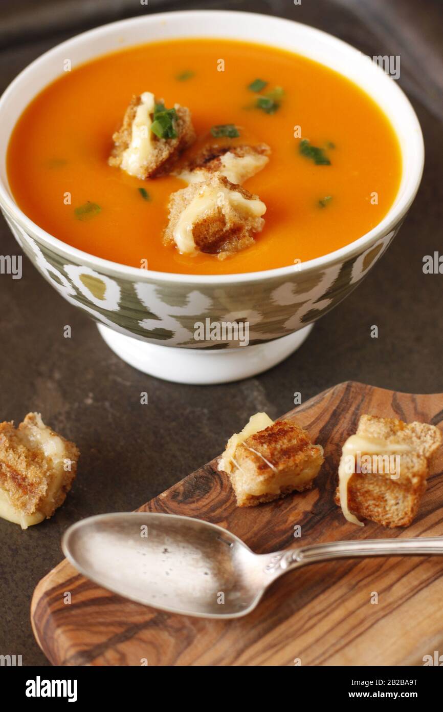 Zuppa di punpkin spessa in una ciotola con piccoli bocconi di crostini di formaggio alla griglia. Foto Stock