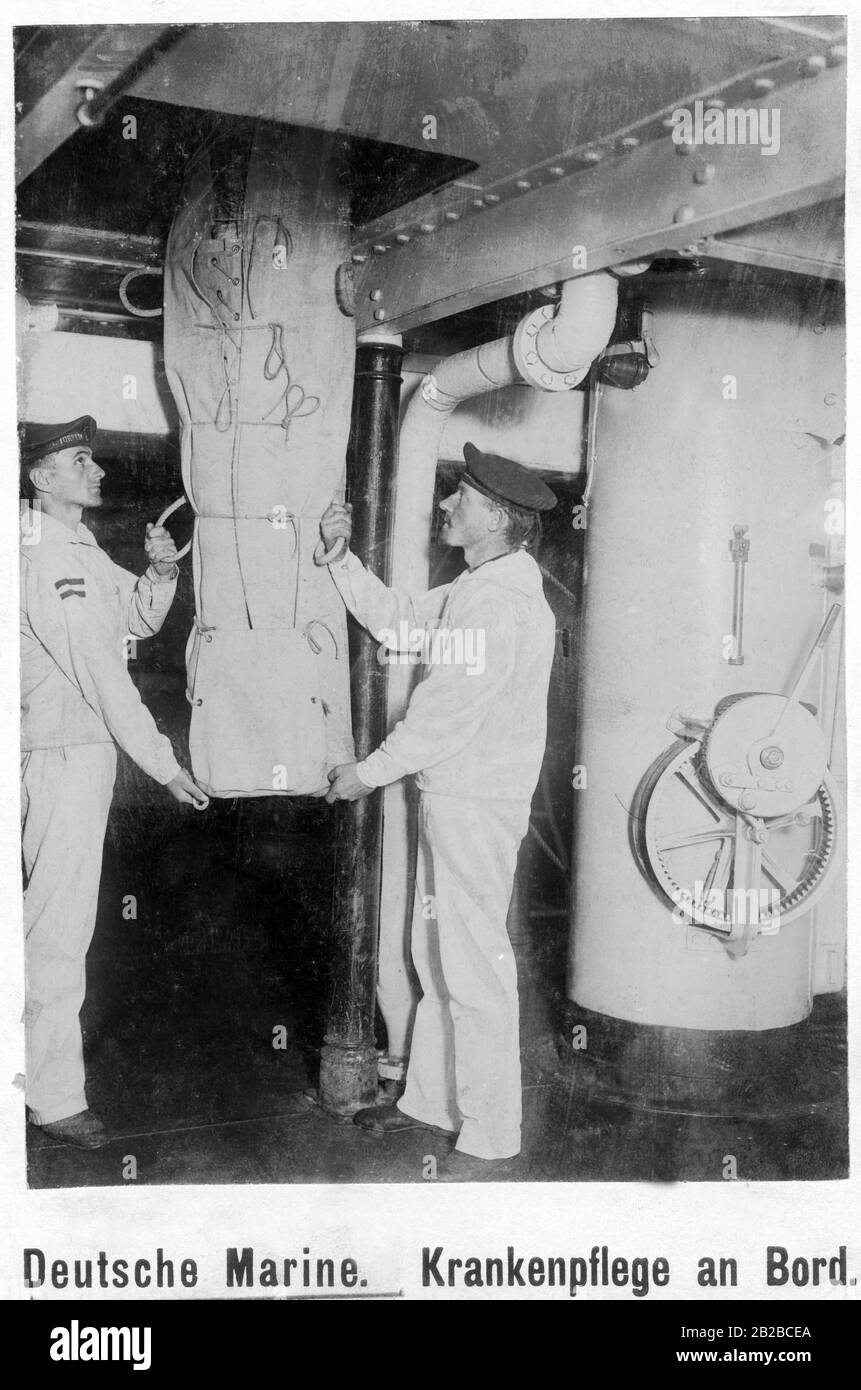 Un uomo ferito a bordo di una nave da guerra della Marina imperiale tedesca è sollevato attraverso un buco in un'amaca di trasporto. Foto non ondulata. Foto Stock Un uomo ferito a bordo di una nave da guerra della Marina imperiale tedesca è sollevato attraverso un buco in un'amaca di trasporto. Foto non ondulata. Foto Stock