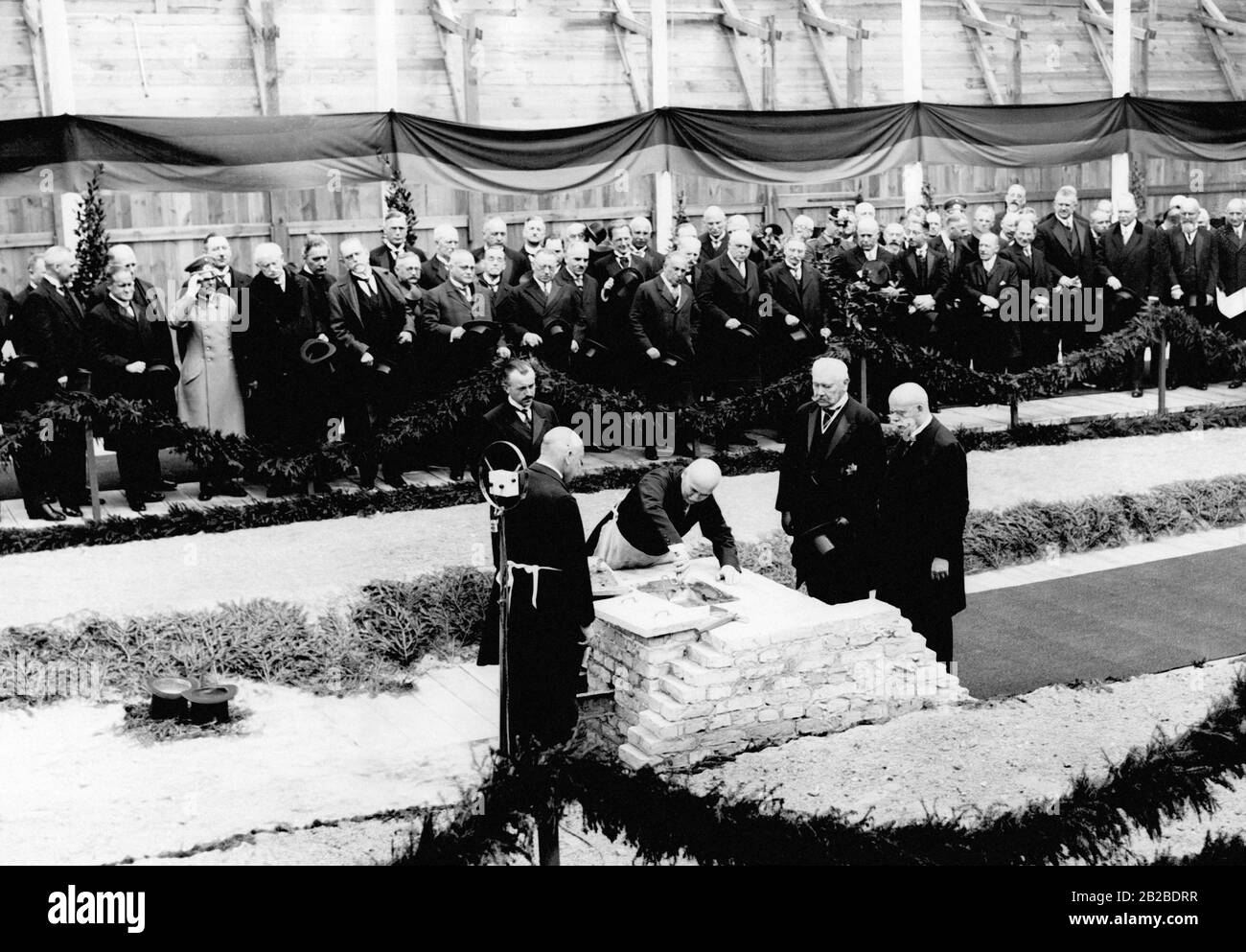 Il Presidente del Reich Paul von Hindenburg, la persona di sinistra dei due in causa e il Cancelliere del Reich, Wilhelm Marx (di destra) che si trova davanti ad un muro che simboleggia la posa della pietra di fondazione dell'estensione della Cancelleria del nuovo Reich. Sullo sfondo ci sono i politici che partecipano all'evento. Foto Stock