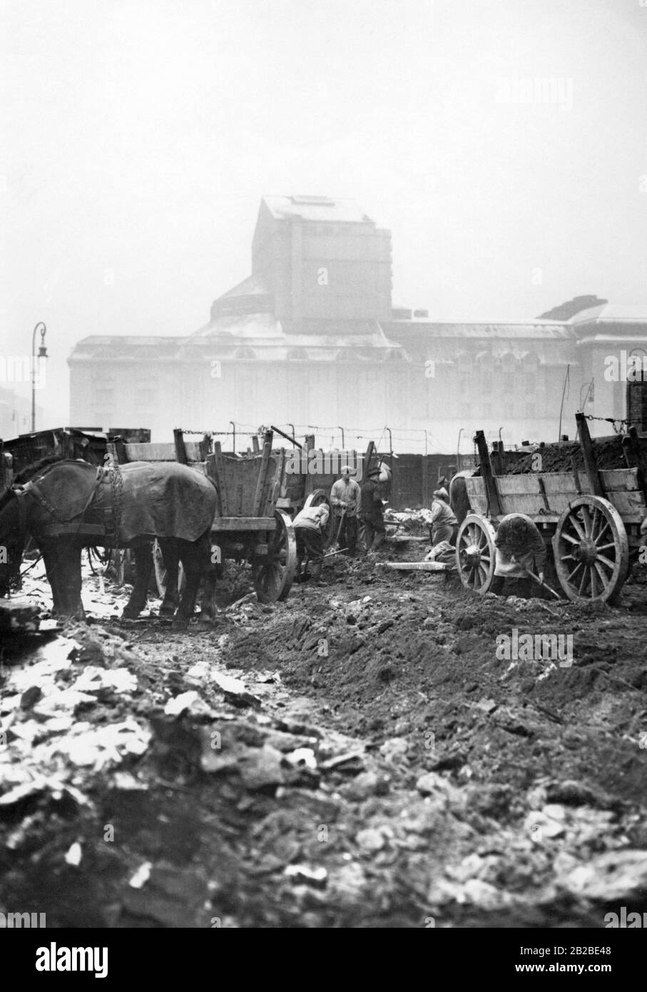 Demolizione dell'ex zona slum, la Scheunenviertel, a Berlino. Il distretto fu combattuto ferocemente durante i combattimenti di strada nel 1919. La figura mostra i lavoratori edili che caricano le prime rovine di demolizione su auto trainate da cavalli. Foto Stock