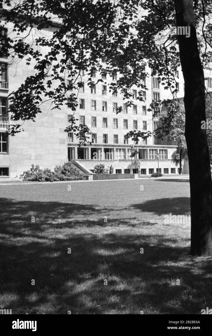 Vista della Cancelleria del nuovo Reich dal giardino. Gli SS camminano a destra dell'albero nel giardino verso l'edificio. Foto non ondulata. Foto Stock