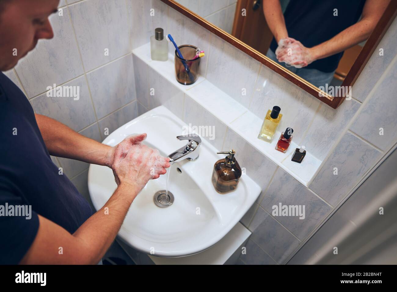 Lavarsi le mani a casa in bagno. Vita sana, igiene e prevenzione malattie virali e batteriche. Foto Stock
