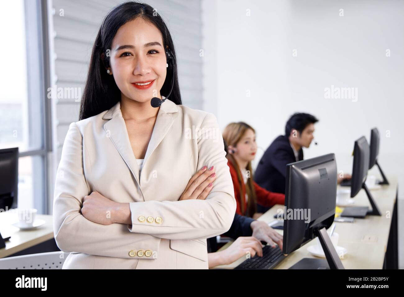 Ritratto di un operatore di call center asiatico felice e sicuro in ufficio. Concetto di servizio di assistenza clienti, stile di vita in ufficio. Foto Stock