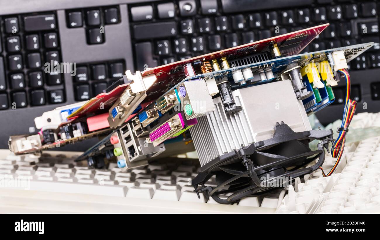 Parti di ricambio hardware e tastiere smontate. Smistamento rifiuti elettronici. Schede grafiche per computer o scheda madre con componenti elettronici, memorie, dissipatore di calore. Foto Stock