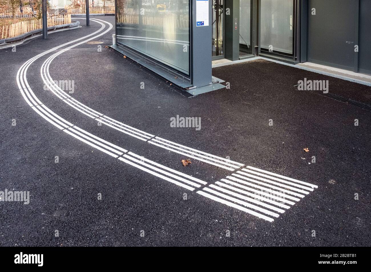 Pedone cieco che cammina e rileva segni sulla pavimentazione tattile per non vedenti e ipovedenti in una stazione Leman Express a Ginevra, Svizzera Foto Stock