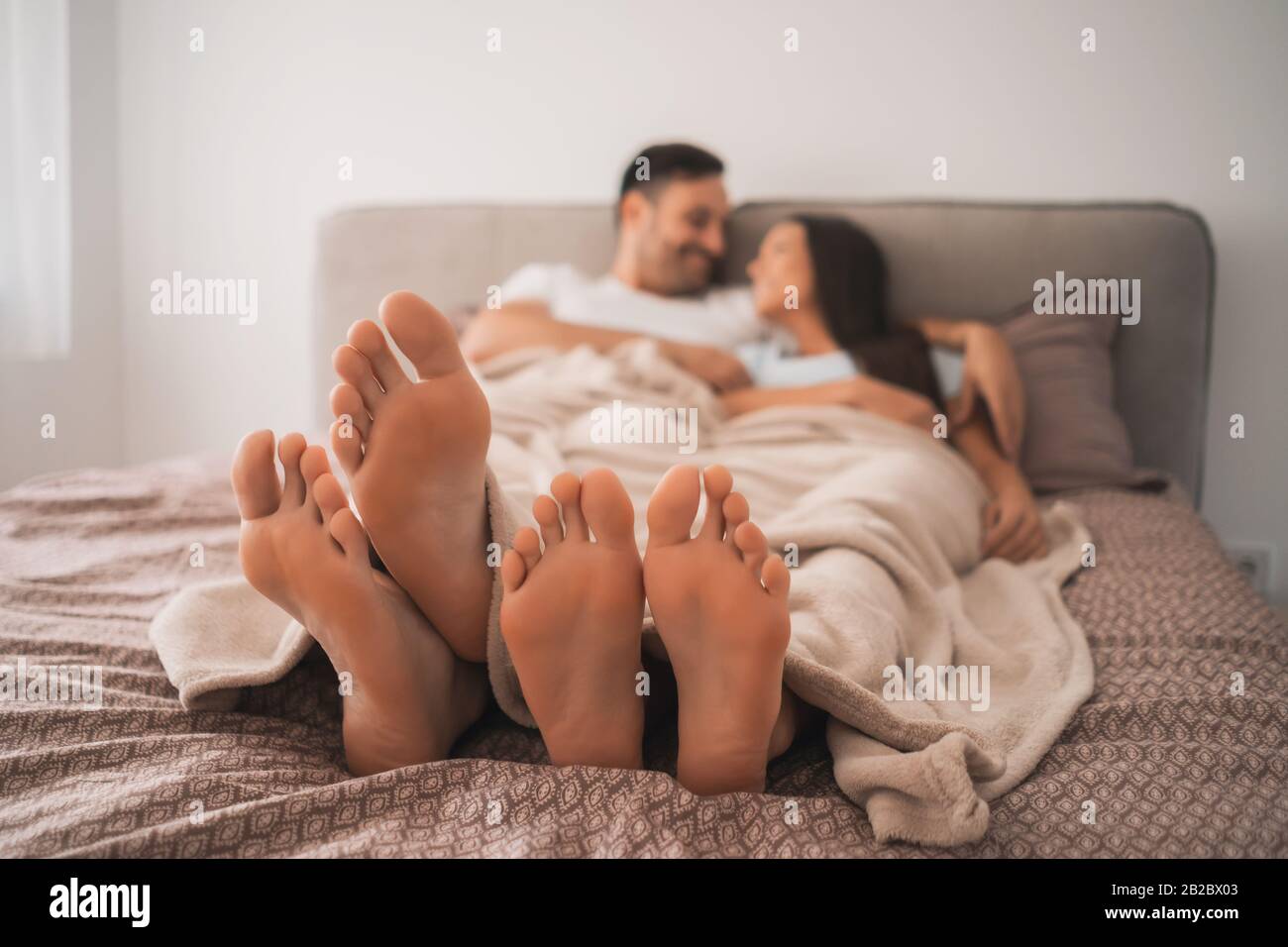 Coppia felice è divertente e rilassante se stessi a letto. Foto Stock