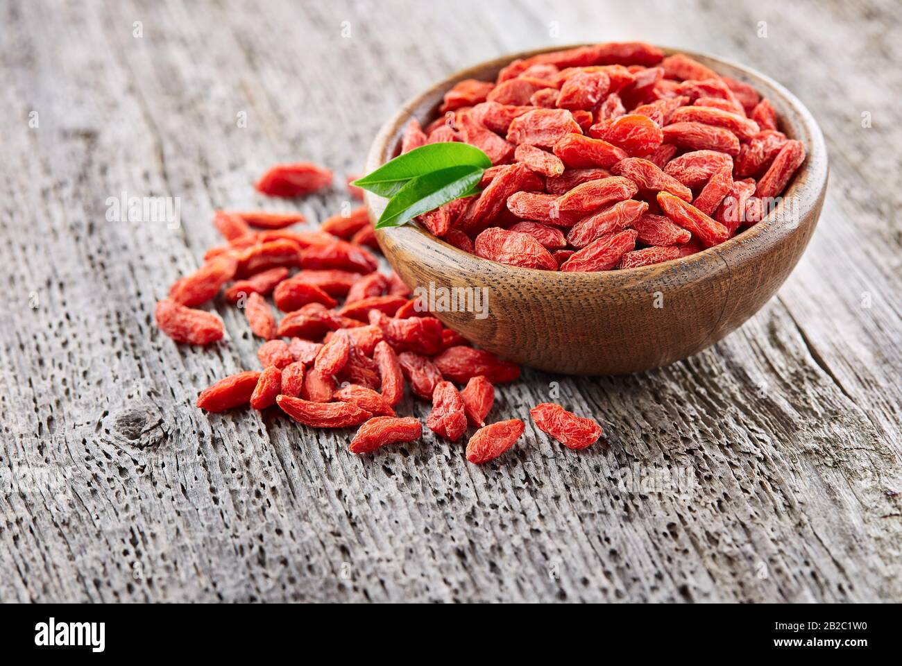 Bacche di Goji su uno sfondo di legno Foto Stock