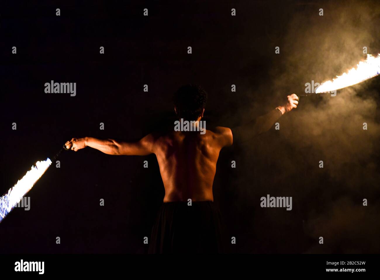Fakir giocoleria fuoco su sfondo nero. Foto Stock
