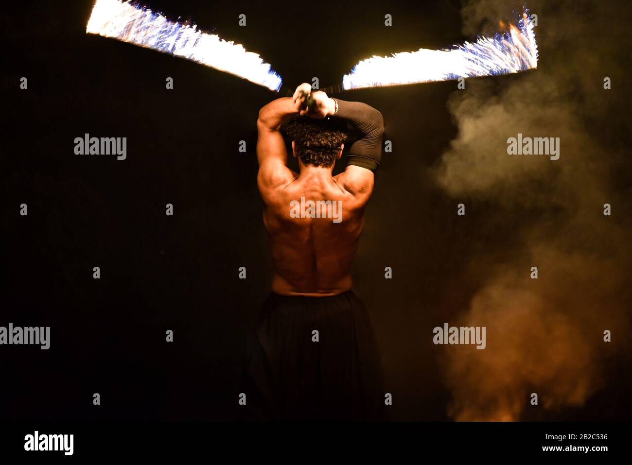 Fakir giocoleria fuoco su sfondo nero. Foto Stock