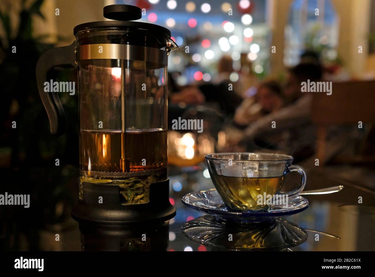 Tè alle erbe fresco in un tè trasparente in un accogliente caffè la sera Foto Stock