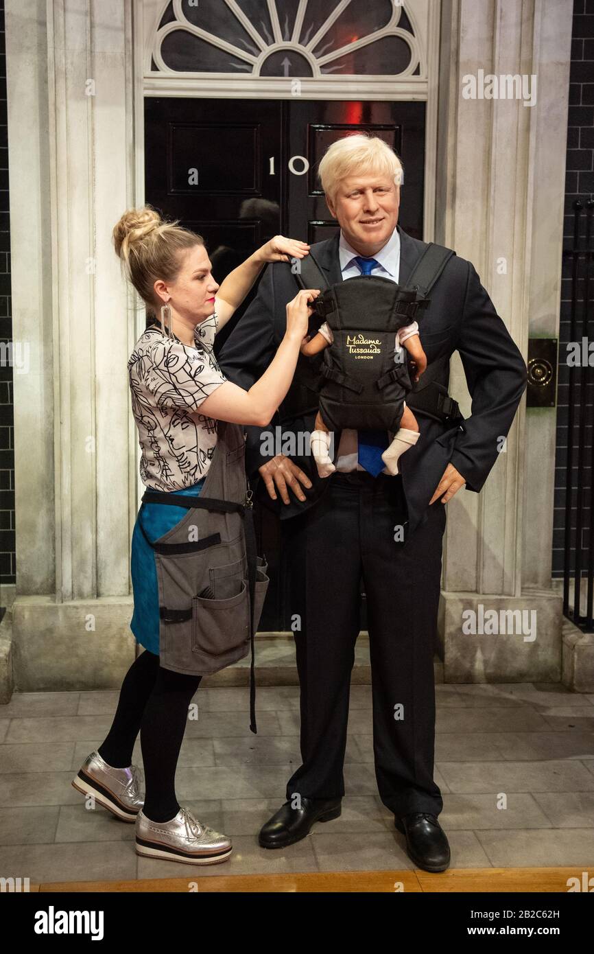 Un artista al Madame Tussauds di Londra si adatta al lavoro di lavoro del museo del primo ministro Boris Johnson con un baby carrier, a seguito del recente annuncio che si aspetta un bambino con il partner Carrie Symonds. Foto Stock