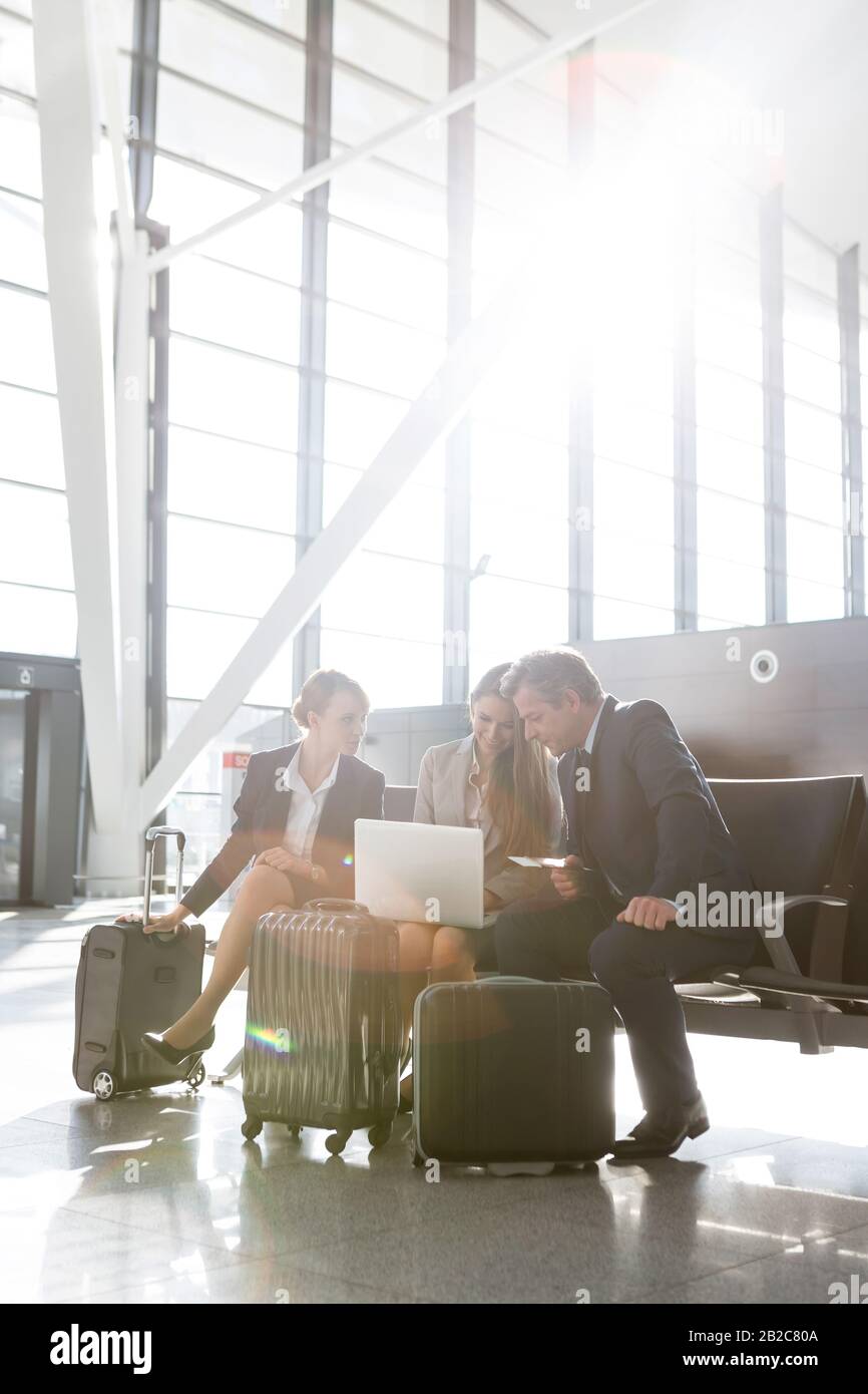 Uomini d'affari che lavorano in attesa di imbarco in aeroporto Foto Stock